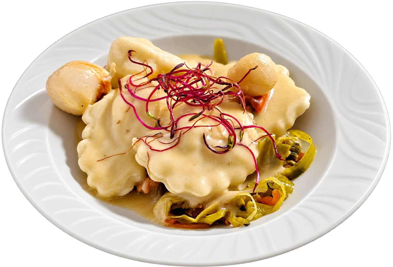 Raviolis nappés de sauce crémeuse avec oignons grelots, fondue de poireaux et pousses rouges, servis dans une assiette creuse blanche.